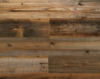 May include: A close-up of a rustic wood wall paneling with a mix of light and dark brown wood planks. The wood has a weathered and distressed look, with knots and grain patterns visible.