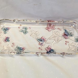 Puede incluir: Un juego de tres tazas de cerámica con un esmalte moteado de color crema. Cada taza presenta un diseño floral pintado a mano en tonos azules, verdes y amarillos. Las tazas tienen una forma simple y redondeada, con un asa cómoda.