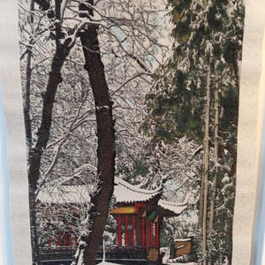 Peut inclure: Une scène d'hiver enneigée avec un bâtiment de style pagode rouge et jaune en arrière-plan. Le bâtiment est entouré d'arbres couverts de neige et un chemin mène à l'avant du bâtiment.