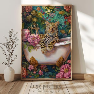 May include: A leopard sits in a white porcelain bathtub surrounded by lush green foliage and pink flowers. The bathtub has gold accents and a faucet with a spout. The leopard has a relaxed expression and is looking directly at the viewer.