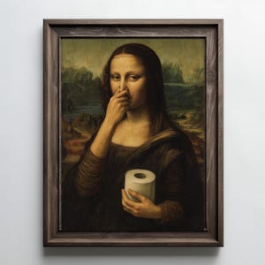 May include: A framed print of the Mona Lisa holding a roll of toilet paper and pinching her nose. The artwork is a parody of the original painting, with a dark brown wooden frame.
