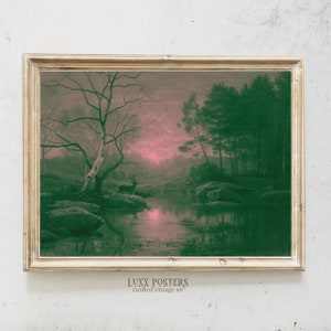 May include: Vintage framed art print of a serene forest scene. The artwork features a deer near a reflective body of water, with a pink and green color palette. The print is in a gold-colored frame. The text "LUXX POSTERS curated vintage art" is at the bottom.