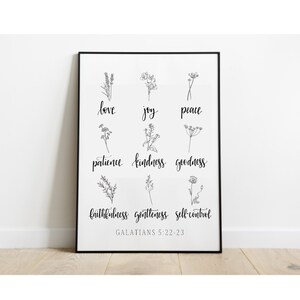 Peut inclure: Une impression murale d'art imprimable en noir et blanc avec une liste de vertus de la Bible, Galates 5:22-23, avec un simple motif floral à côté de chaque mot.