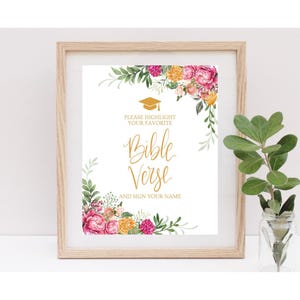 May include: A framed print with floral accents. The print features the words "Bible Verse" in gold script, with the text "Please highlight your favorite and sign your name." A graduation cap graphic is at the top.