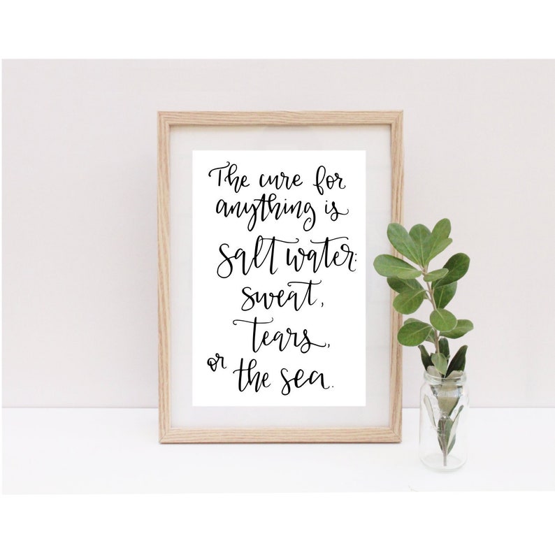 May include: A framed print with a white background and black calligraphy text that reads "The cure for anything is salt water, sweat, tears, or the sea."