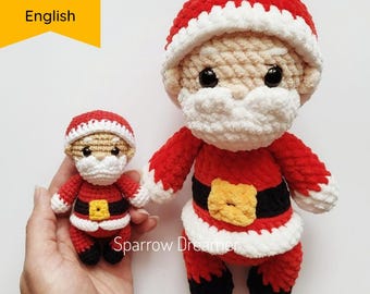 Puede incluir: Dos juguetes de crochet de Papá Noel, uno grande y otro pequeño, ambos con gorros rojos y blancos, barbas blancas y botas negras. El Papá Noel más grande lleva una bolsa de regalos. El Papá Noel más pequeño está de pie sobre una mano. El texto "Sparrow Dreamer" es visible debajo de los juguetes.