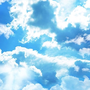 May include: A bright blue sky with fluffy white clouds. The clouds are scattered across the sky, creating a beautiful and peaceful scene.