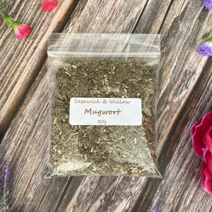 May include: A clear plastic bag filled with dried mugwort herb. The bag has a white label with the text "Sagewick & Willow Mugwort 30g".