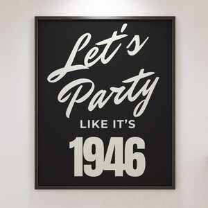 May include: A black framed print featuring the white text "Let's Party Like It's 1946". The artwork uses a mix of script and block lettering. A decorative piece for a home or event.