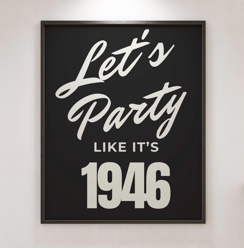 May include: A black framed print featuring the white text "Let's Party Like It's 1946". The artwork uses a mix of script and block lettering. A decorative piece for a home or event.