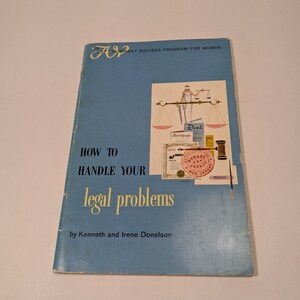 May include: A vintage book titled "How to Handle Your Legal Problems" by Kenneth and Irene Donelson. The cover is light blue with the title in yellow and a graphic of a scale, a notary stamp, and a gavel.