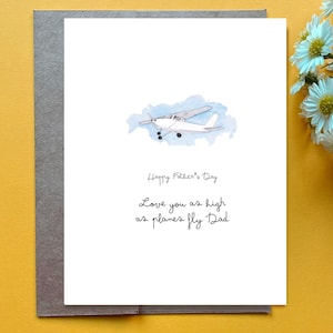 May include: A Father's Day greeting card with a watercolor illustration of a small airplane against a blue sky. The card reads "Happy Father's Day" and "Love you as high as planes fly Dad."