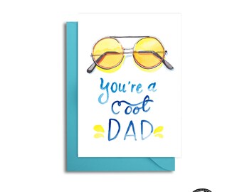 May include: A white card with a blue watercolour background. The card features a pair of yellow sunglasses and the text "You're a cool DAD".