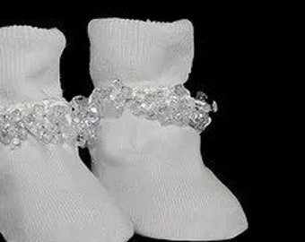 May include: White baby socks with a frilly lace trim around the ankle.