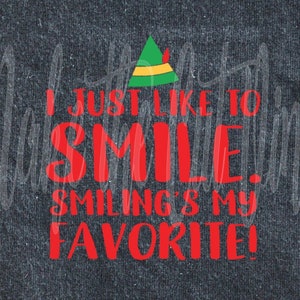 May include: Red text on a dark grey background reads "I just like to smile. Smiling's my favourite!" with a green and yellow elf hat above the text.