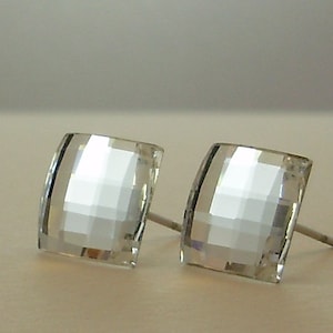May include: A pair of clear crystal square stud earrings with silver posts.