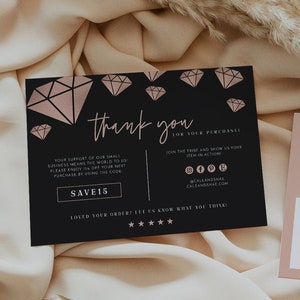 Può includere: Un biglietto di ringraziamento nero con illustrazioni di diamanti rosa e il testo "grazie per il tuo acquisto". Il biglietto include anche un codice sconto del 15% e icone dei social media. È mostrata anche una carta rosa con il testo "Il tuo logo qui".