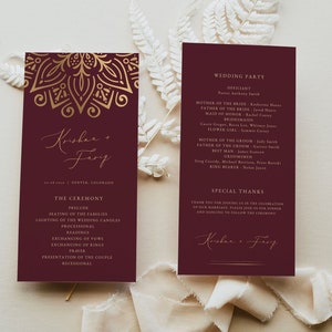 May include: A burgundy wedding ceremony programme with gold accents and a mandala design. The programme lists the order of events for the ceremony, including the seating of the families, lighting of the wedding candles, readings, exchanging of vows, exchanging of rings, and the presentation of the couple. The programme also includes the names of the wedding party and a special thanks section.