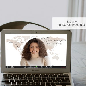Puede incluir: Una pantalla de ordenador portátil que muestra un fondo de Zoom con un mapa del mundo y el texto "Carmen's Baby Shower" en una fuente manuscrita. El fondo es beige y marrón con un corazón y un icono de avión. Una mujer es visible en la transmisión de video.