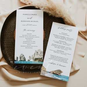 May include: Wedding ceremony program with a watercolor illustration of a rocky beach scene. The program includes the names Isabella Marie and Harrison Michael, the date of the wedding, and the order of events. The wedding party is listed on the back of the program.