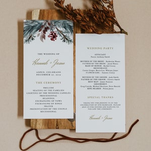 以下が含まれることがあります： 松の枝と赤い実の水彩画のデザインが施された結婚式プログラム。プログラムには、結婚式パーティー、式典の順番、特別な感謝の言葉が記載されています。テキストには「The Wedding of Hannah + Jason, Aspen, Colorado, December 07, 2019」とあります。