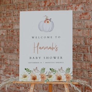 Może przedstawiać: Witamy na Baby Shower Hannah, znak z białą dynią z kwiatowymi akcentami i kwiatową ramką. Znak zawiera r&oacute;wnież datę 08 września i lokalizację Manitou Springs.