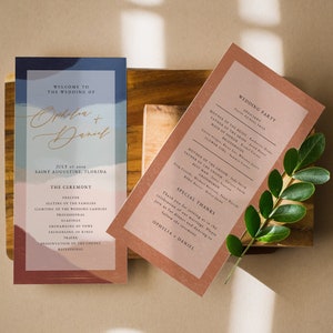 Peut inclure: Cartes de programme de cérémonie de mariage avec un design abstrait bleu et rose à gauche et une carte de couleur pêche avec les informations sur la fête de mariage à droite. Le texte sur la carte de gauche se lit comme suit : "Bienvenue au mariage d'Ophelia + Daniel 7 juillet 2019 Saint Augustine, Floride La cérémonie Prélude Placement des familles Allumage des bougies de mariage Procession Lectures Échange des vœux Échange des alliances Prière Présentation du couple Recessional". Le texte sur la carte de droite se lit comme suit : "Fête de mariage Officiant Père de la mariée Mère de la mariée Demoiselle d'honneur Demoiselle d'honneur Fleuriste Mère du marié Père du marié Témoin d'honneur Garçons d'honneur Porteur d'alliances Remerciements spéciaux Merci de vous joindre à nous pour célébrer notre mariage. Veuillez nous rejoindre pour le dîner et la danse après la cérémonie. Ophelia + Daniel"