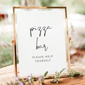 以下が含まれることがあります： 黒い筆記体で「pizza bar」と書かれた金色の額縁の看板。テキストの下には、黒いサンセリフ体で「Please help yourself」と書かれています。