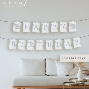 May include: A 'HAPPY BIRTHDAY' banner in light blue, with snowflake motifs, strung across a room. The banner hangs above a white sofa and a small table. The words 'EDITABLE TEXT!' are also visible in the image.