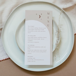May include: A beige menu card with a brown moon and stars design. The menu lists a three-course meal with options for "To Start", "To Follow", "To Finish", and "Dessert".