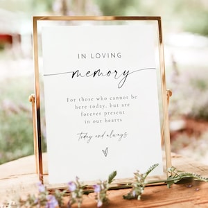 May include: A white sign with a gold frame, reading "IN LOVING memory" in black script. The sign also includes the text "For those who cannot be here today, but are forever present in our hearts Today and always".