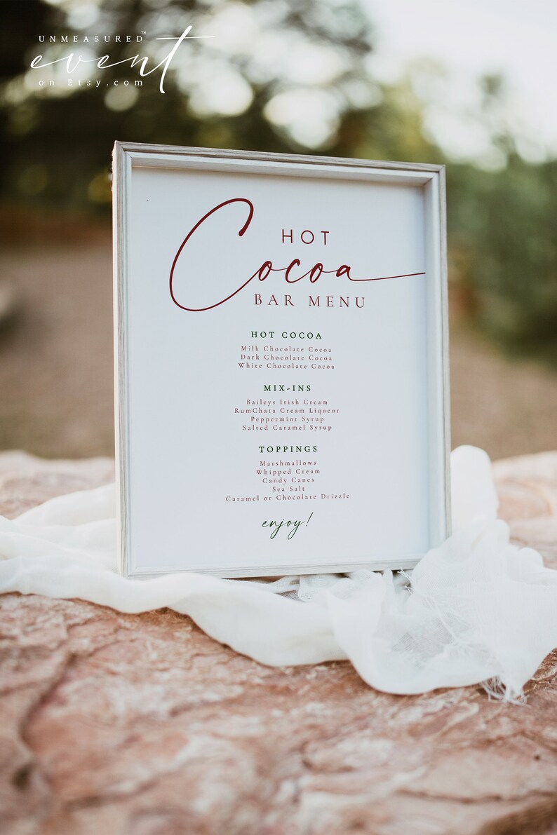 BLAIR Festive Red and Green Modern Christmas Hot Cocoa Bar Menu Sign Printable Template outdoors on a red rock with white cheesecloth