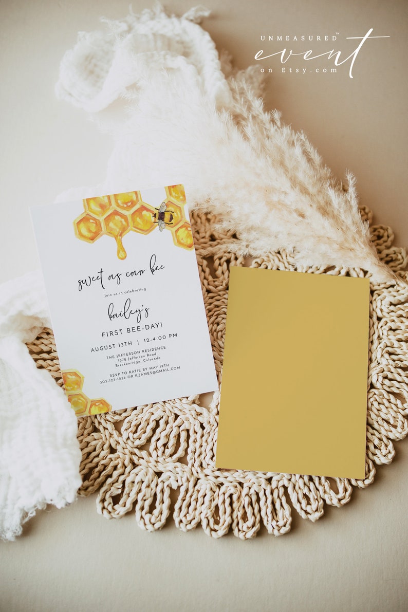 May include: A honeybee themed invitation for a first birthday party. The invitation features a watercolor illustration of a honeycomb with a bee and dripping honey. The text on the invitation reads "sweet as can bee" and "bailey's first bee-day!"  The invitation also includes the date, time, and location of the party.