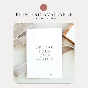 Puede incluir: Tarjeta blanca con el texto "UPLOAD YOUR OWN DESIGN" en fuente negra. La tarjeta est&aacute; sobre una superficie blanca con una cinta beige y un marco de madera.