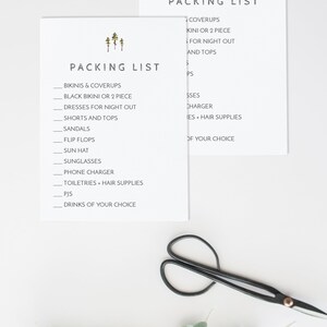 May include: Two white cards with a packing list for a trip. The list includes items like bikinis, coverups, dresses, shorts, sandals, flip flops, sun hats, sunglasses, phone chargers, toiletries, pajamas, and drinks. The cards have a simple design with a small image of three pine trees at the top.