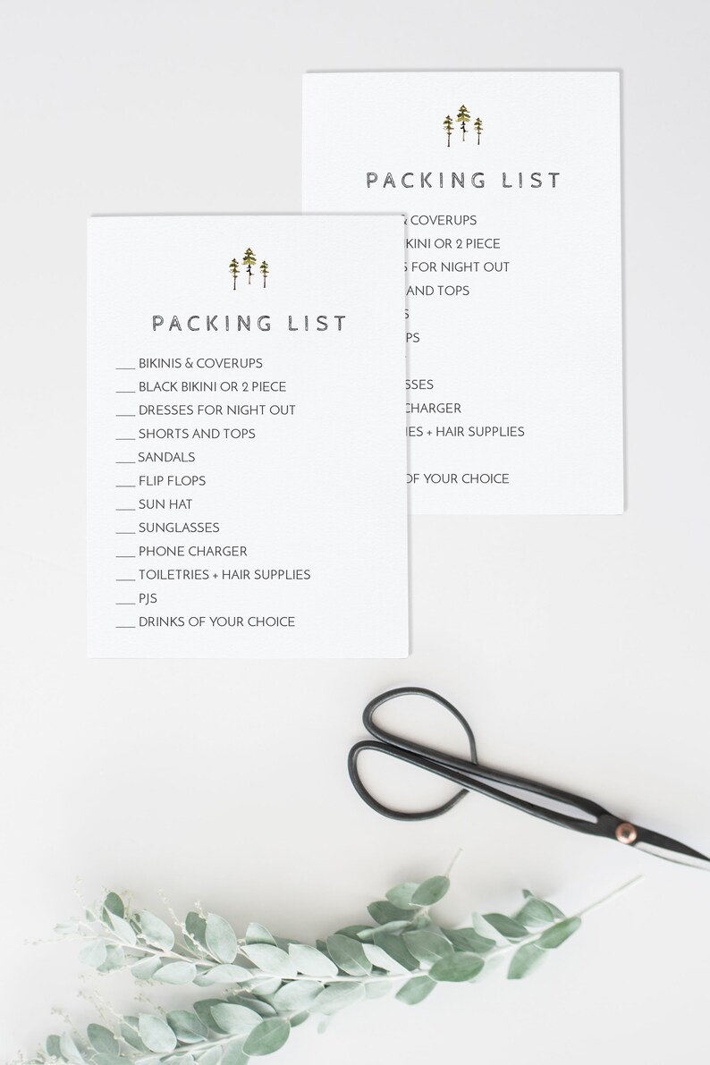 May include: Two white cards with a packing list for a trip. The list includes items like bikinis, coverups, dresses, shorts, sandals, flip flops, sun hats, sunglasses, phone chargers, toiletries, pajamas, and drinks. The cards have a simple design with a small image of three pine trees at the top.