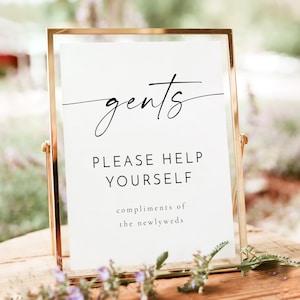 May include: A gold-framed sign with the text "gents" in cursive script, followed by "Please help yourself" and "compliments of the newlyweds".