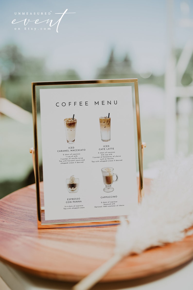 Pu&ograve; includere: Un cartello con cornice dorata, sfondo bianco e testo nero che elenca un menu di caff&egrave;. Il menu include Iced Caramel Macchiato, Iced Cafe Latte, Espresso Con Panna e Cappuccino. Ogni bevanda al caff&egrave; &egrave; illustrata con un'immagine ad acquerello.