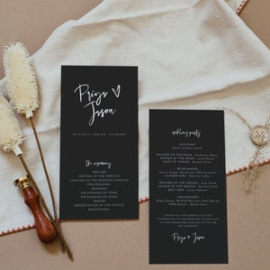 May include: Black wedding ceremony program cards with white calligraphy text. The cards list the ceremony details, wedding party, and names. The cards are on a neutral background with decorative elements.