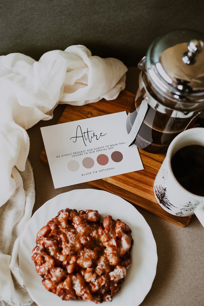 May include: A white card with the word "Attire" written in black cursive. The card also includes a colour palette with four shades of brown and the text "We kindly request our guests to wear these colours to our special day. Black-tie optional."