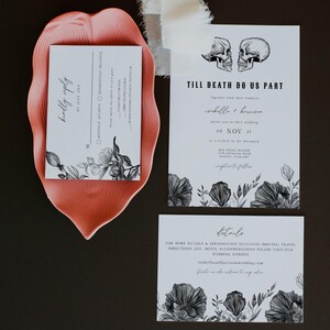 May include: Wedding invitation suite with a black and white floral design. The invitation features two skulls with the text "Till Death Do Us Part". The RSVP card has the text "Kindly Reply by July 2nd".