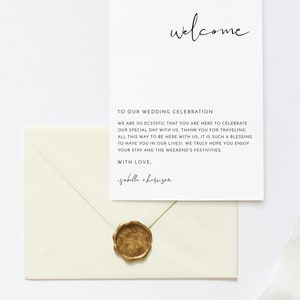May include: A white envelope with a gold wax seal. The envelope has a white card inside with the text "welcome" in cursive at the top and the text "TO OUR WEDDING CELEBRATION" in all caps below. The text continues with "WE ARE SO ECSTATIC THAT YOU ARE HERE TO CELEBRATE OUR SPECIAL DAY WITH US. THANK YOU FOR TRAVELING ALL THIS WAY TO BE HERE WITH US, IT IS SUCH A BLESSING TO HAVE YOU IN OUR LIVES! WE TRULY HOPE YOU ENJOY YOUR STAY AND THE WEEKEND'S FESTIVITIES. WITH LOVE, isabella + harrison"