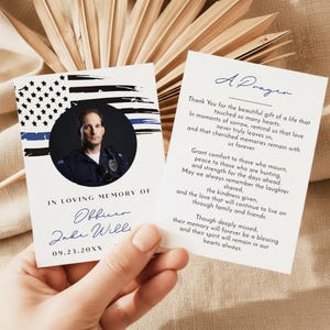 May include: Memorial card with a photo of an officer in uniform, a blue line flag, and the text "In Loving Memory of Officer Jake Willi." The card includes a prayer on the back, with a message of remembrance and comfort.