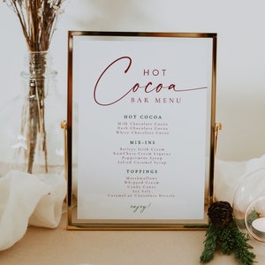 BLAIR Festive Red and Green Modern Christmas Hot Cocoa Bar Menu Sign Printable Template on a holiday table with candles and pine branches
