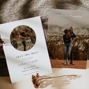May include: Save the date card with a white background and a circle cutout featuring a couple in a snowy landscape. The text reads "Save the date for the wedding of milena + corbin 07.15.20XX Aspen, Colorado formal invitation to follow".