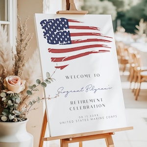 May include: A white sign on a wooden easel features an American flag design in red and blue. The sign reads "Welcome to Sergeant Bilyeau's Retirement Celebration" with the date and "United States Marine Corps" below.
