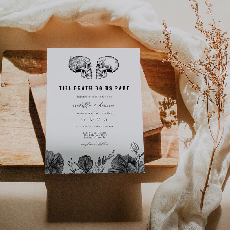 May include: A wedding invitation with a black and white illustration of two skulls with floral accents. The text reads "Till Death Do Us Part" with the names "Isabella + Harrison" and the date "08 NOV 21".