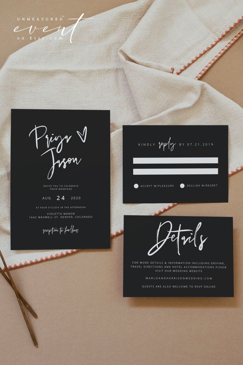 May include: Elegant black wedding invitation suite with white calligraphy. The invitation includes names, date, and location. RSVP and details cards are also included. The suite is set on a neutral linen background.