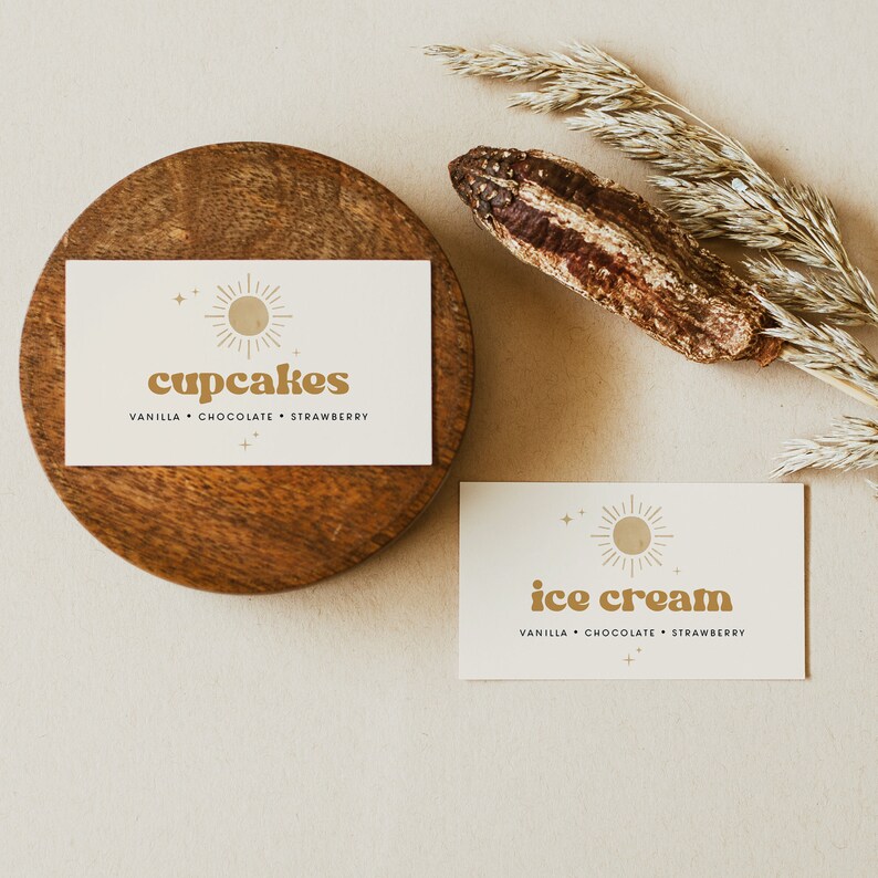 May include: Two white cards with a gold sun graphic and text. The top card says "cupcakes" with the text "vanilla, chocolate, strawberry" below. The bottom card says "ice cream" with the text "vanilla, chocolate, strawberry" below.