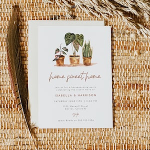 May include: A white card with a housewarming party invitation. The card features a watercolor illustration of three potted plants with green leaves. The text reads "home sweet home" in a brown script font. The invitation is for Isabella & Harrison and is being held at 1532 Maxwell Street in Denver, Colorado on Saturday, June 15th at 2:00 PM. The RSVP information is Jamie Roads at 303.123.1234.
